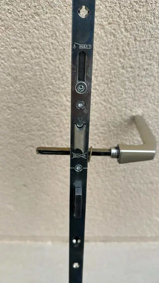 Crémone de serrure multipoints en cours de pose