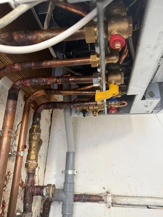 Raccordements gaz et chauffage sous une chaudière murale
