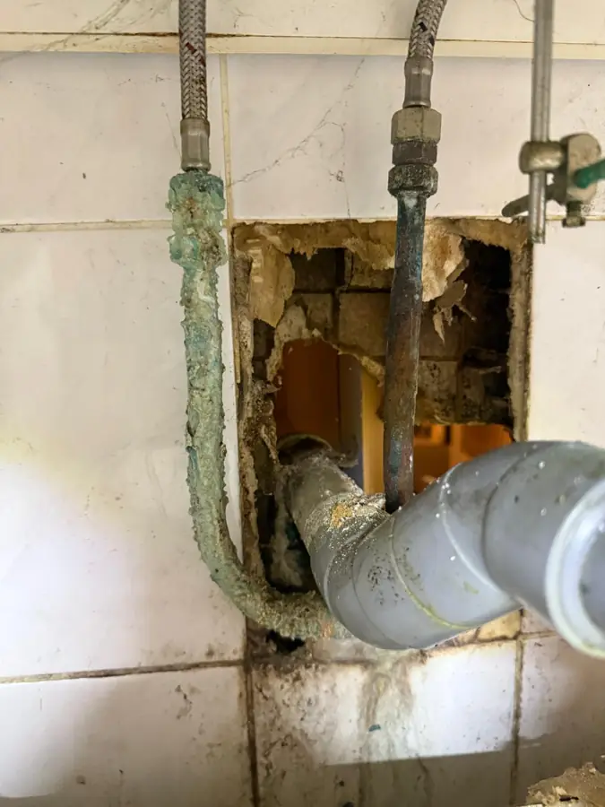 Raccords corrodés et fuyards découverts derrière un carrelage