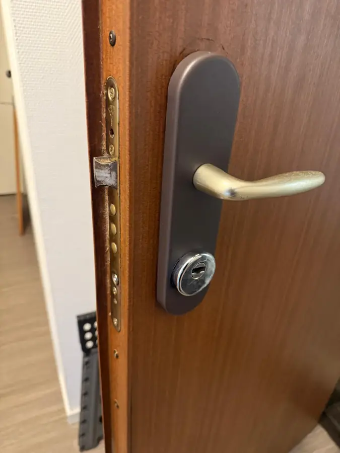 Serrure neuve et poignée posées sur une porte d'entrée